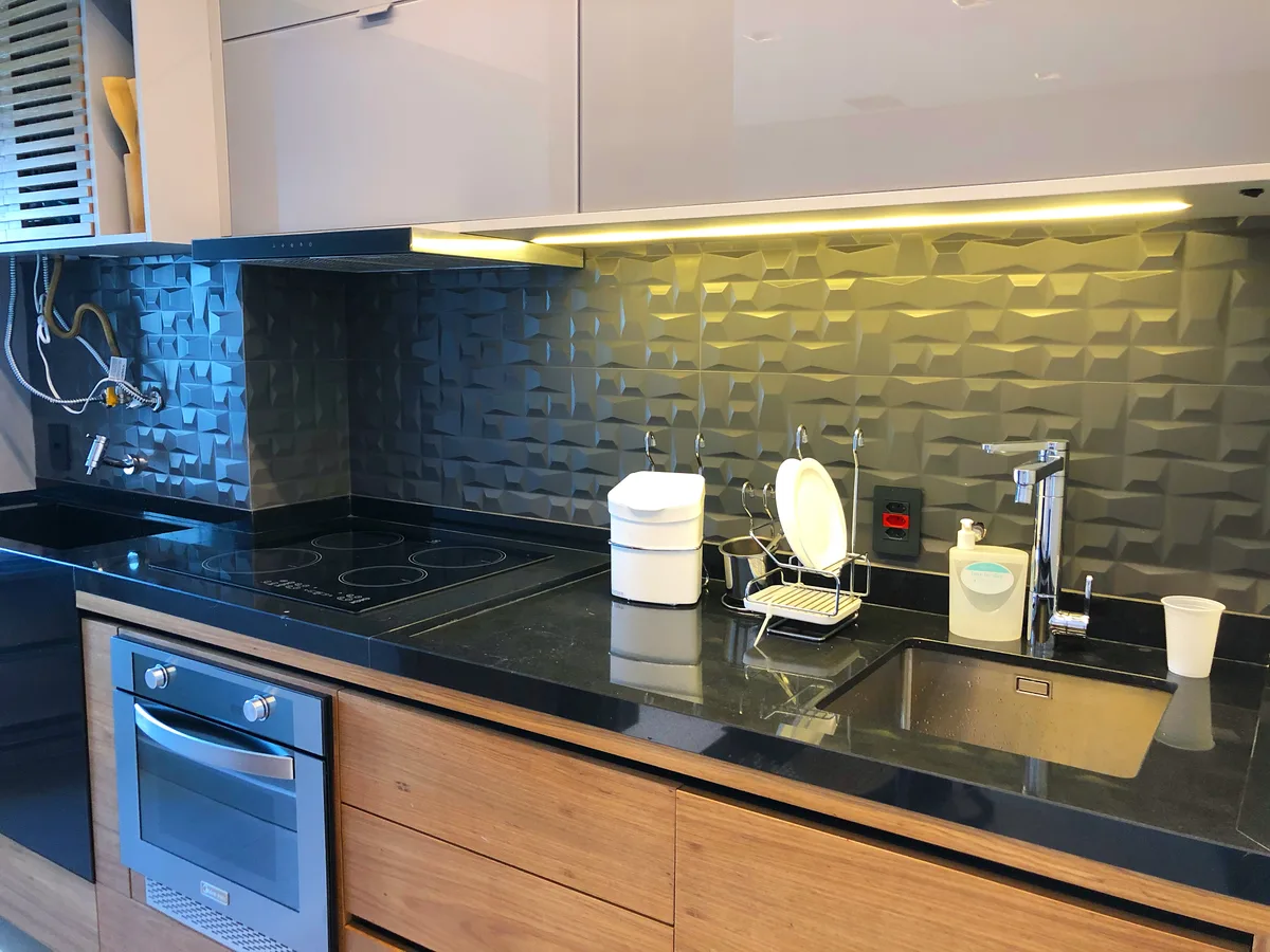 Cozinha planejada com revestimento 3D e bancada em pedra